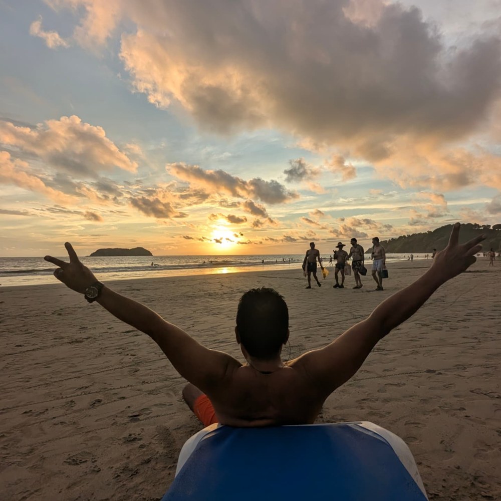 Guest celebrating the sunset from a beach lounger on Playa Espadilla in Manuel Antonio