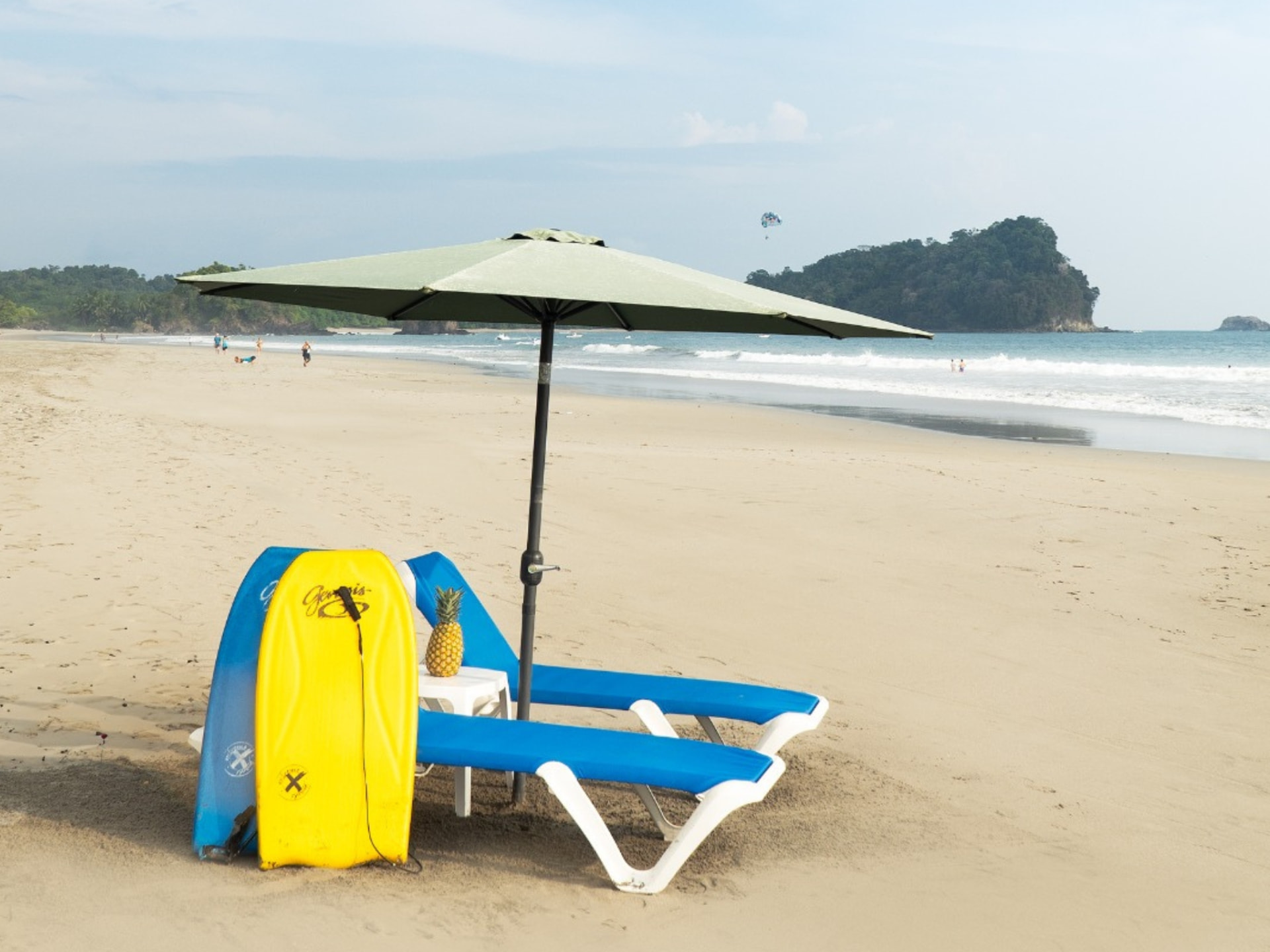 Blue loungers, shade umbrella, boogie boards and fresh pineapple on Playa Espadilla